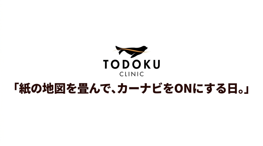 紙の地図を畳んでカーナビをONにする日。TODOKU CLINICのロゴとメッセージ